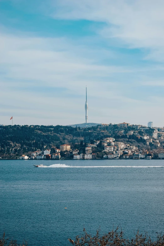 there is a boat on the water with a city in the distance