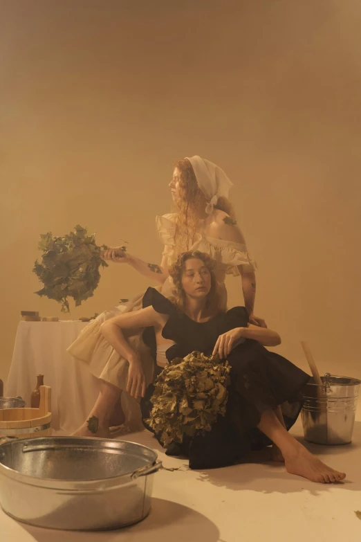 three young women dressed in costumes sitting on the ground