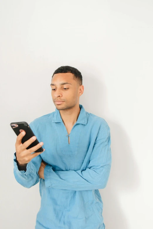 a man in a blue shirt holding a cell phone