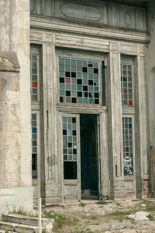 an old run down, boarded up building has glass on the doors