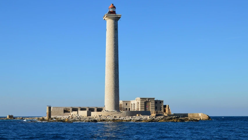 a large tall tower with a light house in the middle of the ocean