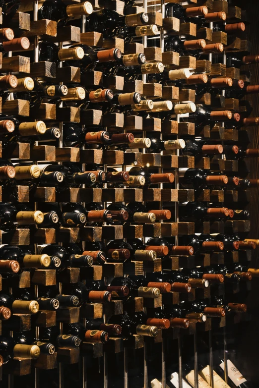 a bunch of bottles of wine are stacked together on the wall
