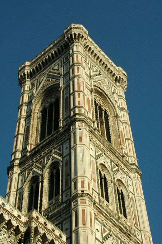 a very tall stone building has windows on each level