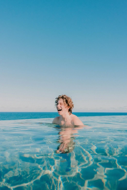 a man standing in shallow water on top of the ocean