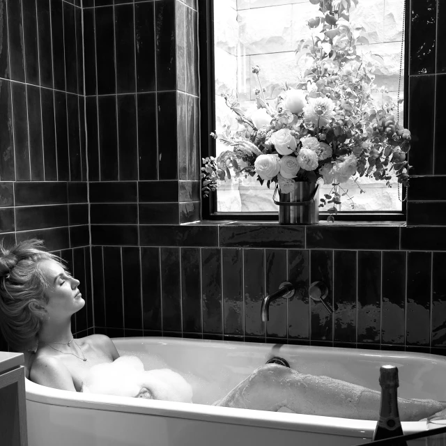 a woman taking a bath in a small bathtub
