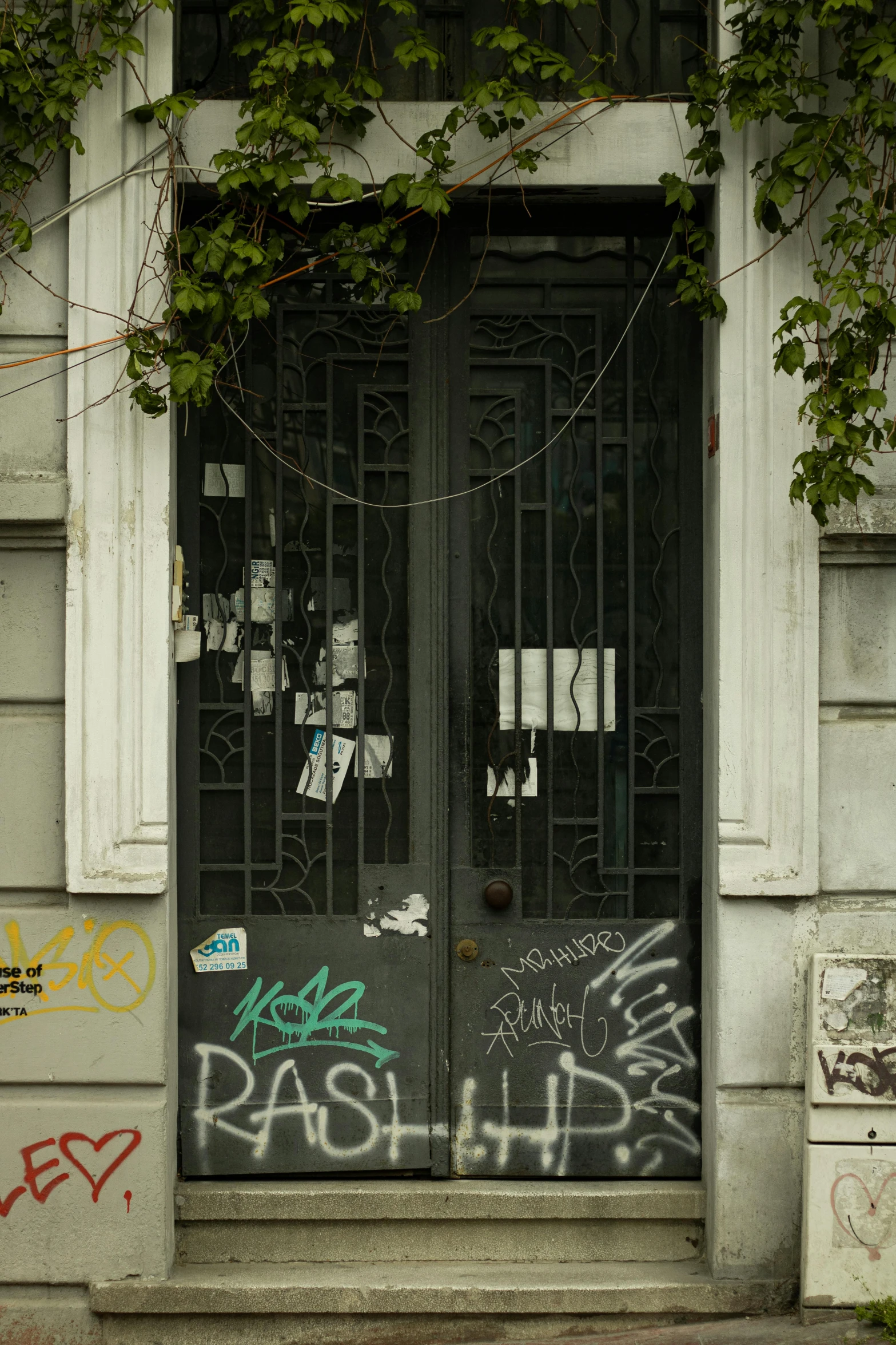 an entrance to a run down building with graffiti on the door