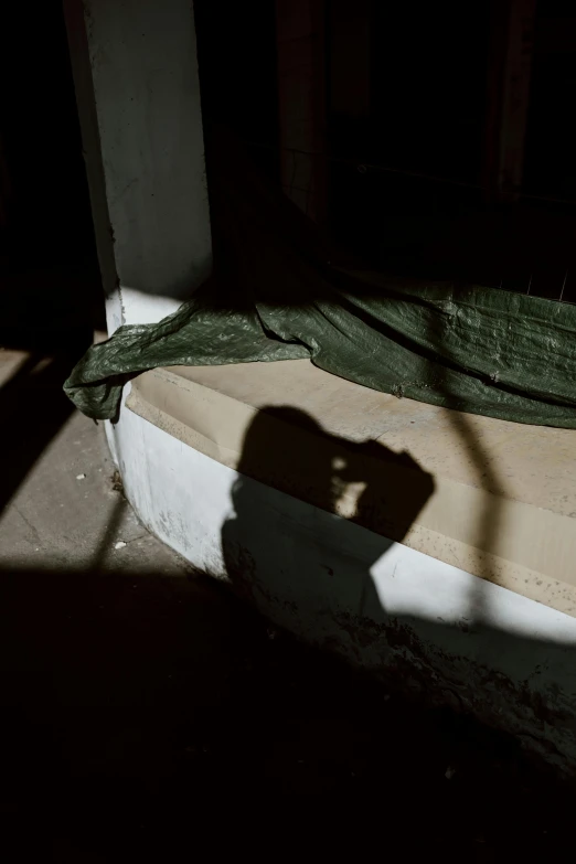 the shadow of a hand touching a green tarp