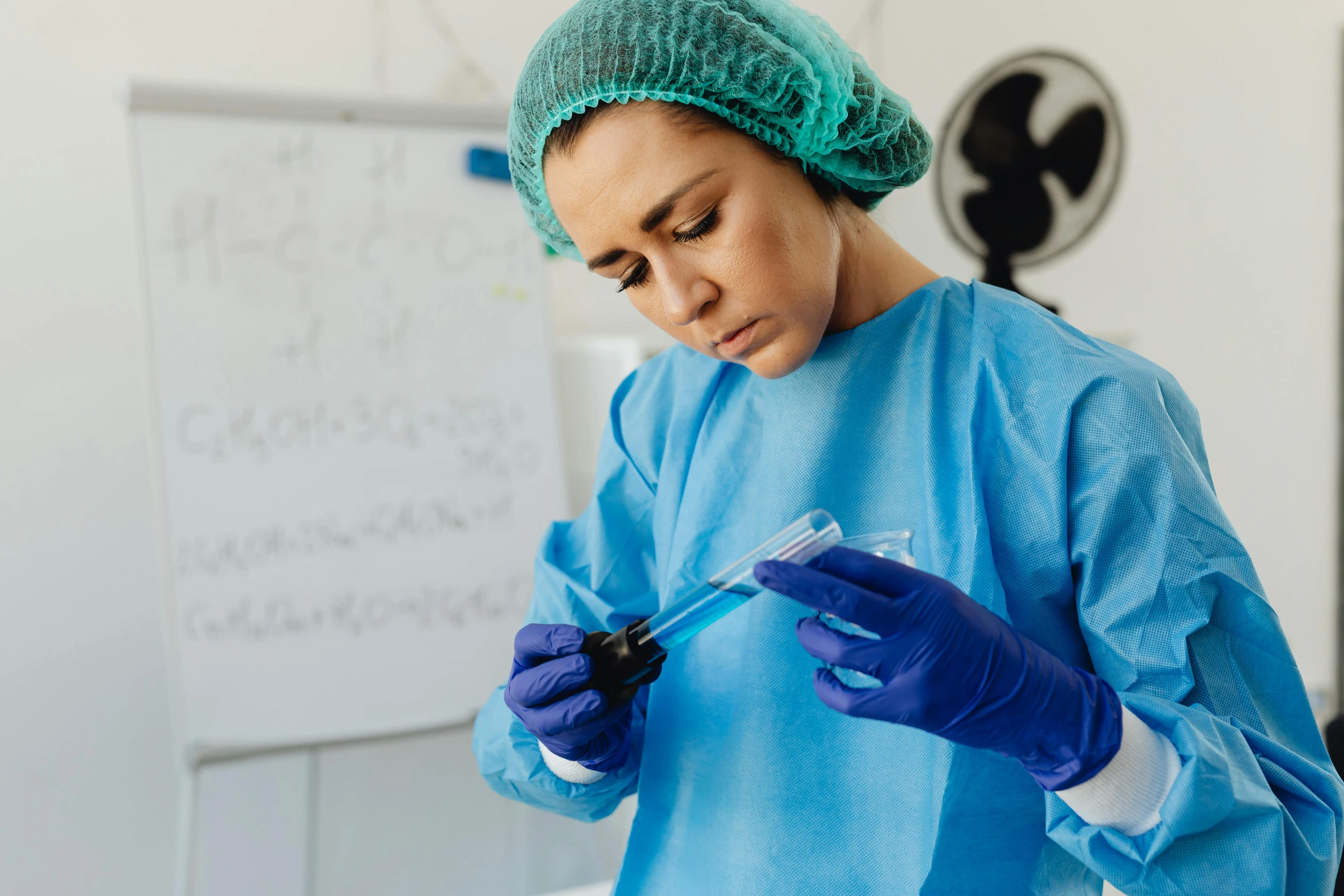 a person wearing surgical gloves and holding a container