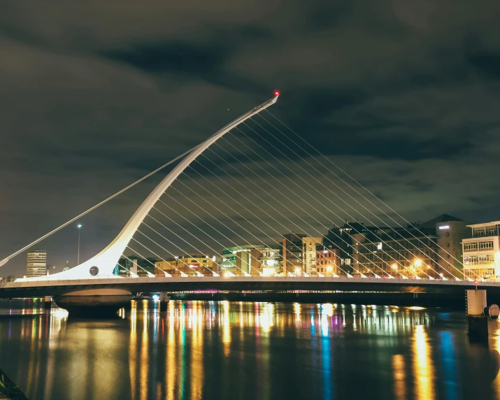 a bridge over the water in a city at night