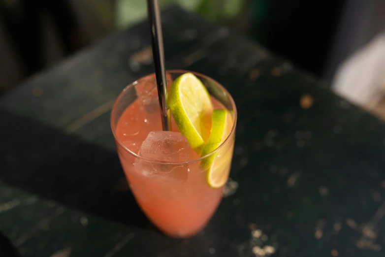 a cocktail with lemons and lime on the side