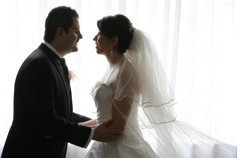 a bride and groom in front of the window together