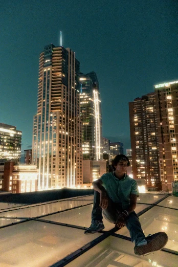 a man sitting on the rooftop of a building at night