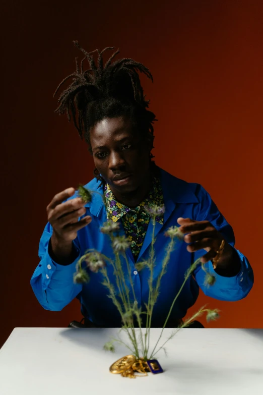 a man with dreadlocks is sitting at a table