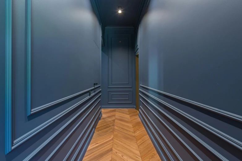 a room with a blue painted wall and wooden floors