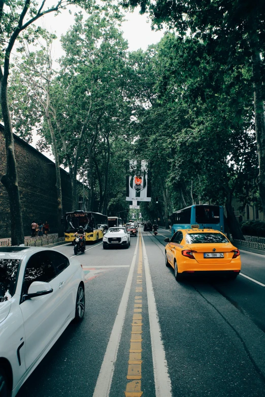 two cars driving in opposite directions, one is yellow