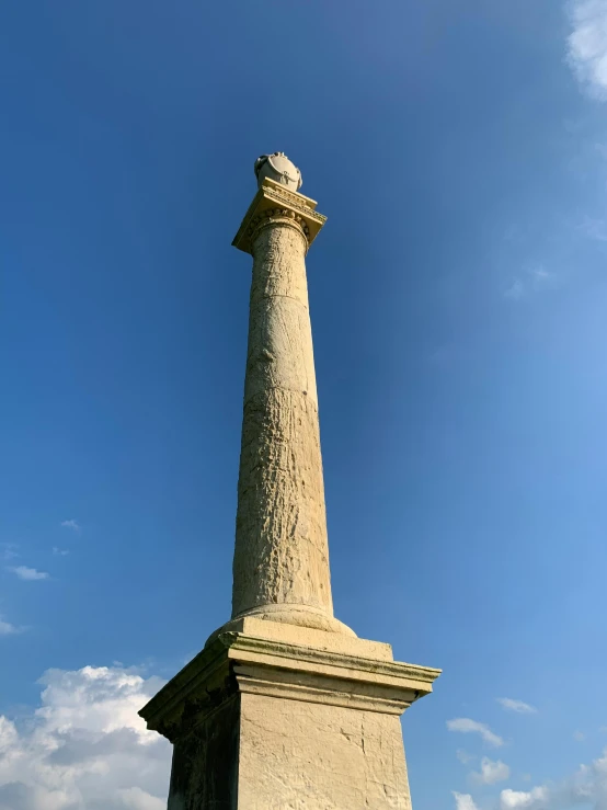 a tall white stone pillar with a sky background