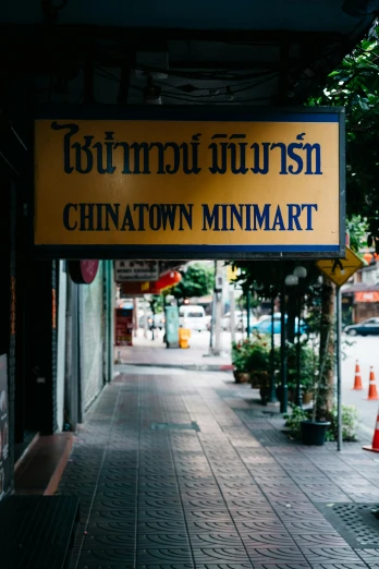 a yellow sign on the side of the street reads chinatown minimart