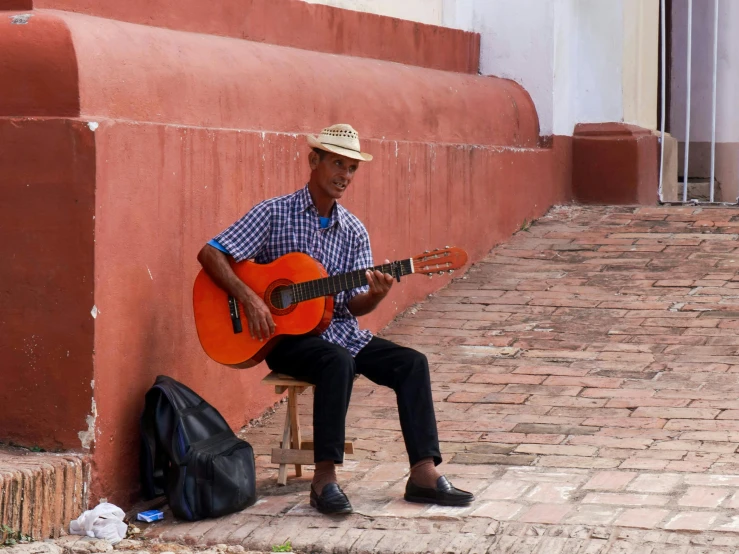 the man is playing a guitar while sitting down