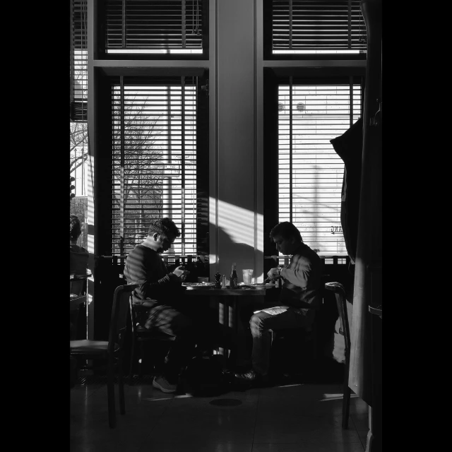 a couple of people sitting at a table in a room