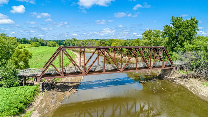 a rusty, old train bridge over a river