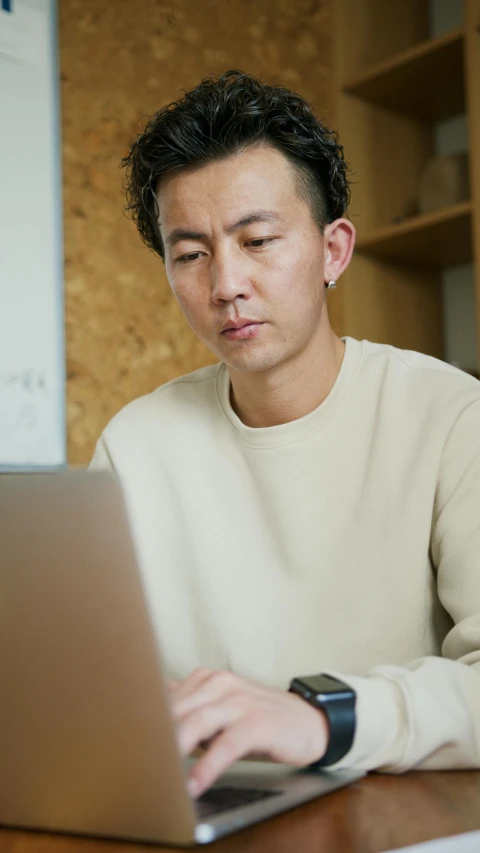 asian man on his laptop in a liry