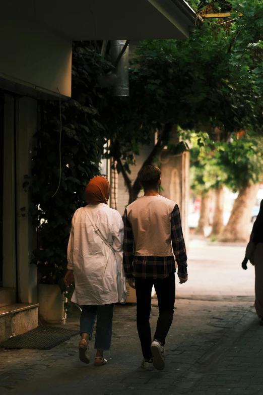 a man and woman walk down a city street