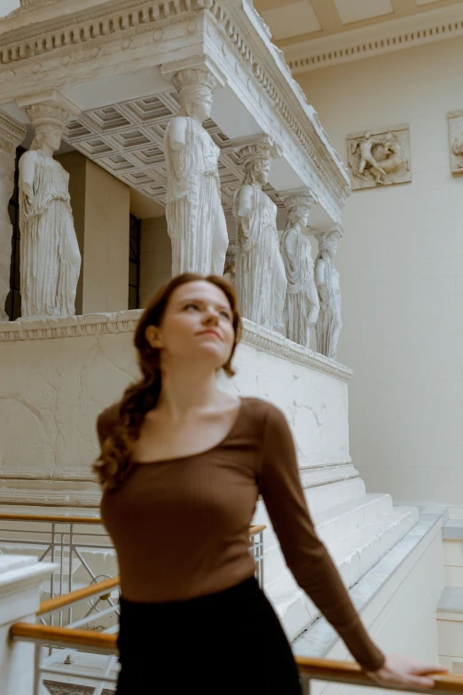 a beautiful woman standing in front of a statue