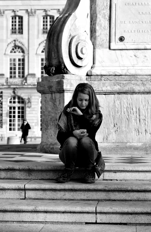 woman on steps looking down at her cell phone