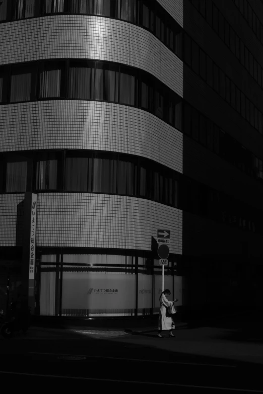 a man stands in the street with his laptop near a tall building