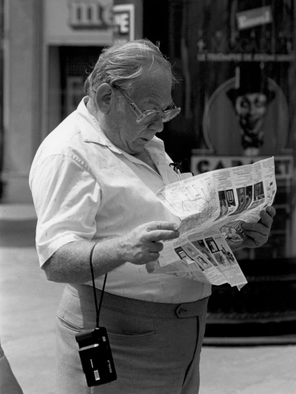 an old man holding onto the street paper