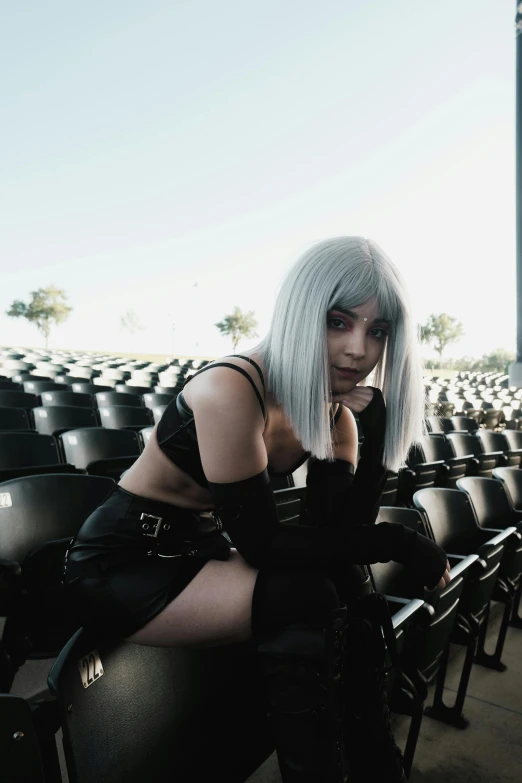 a woman with grey hair is sitting in a stadium