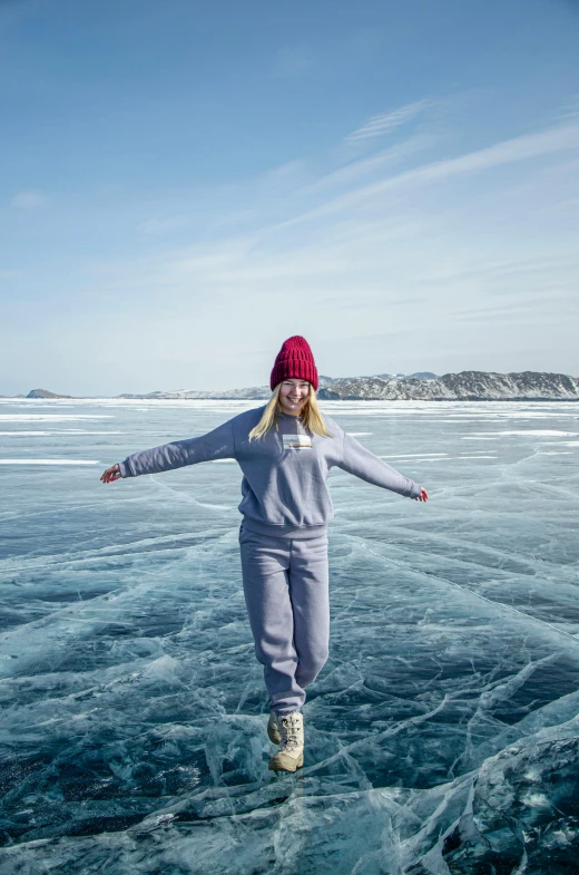 a woman walking across a frozen lake under a blue sky