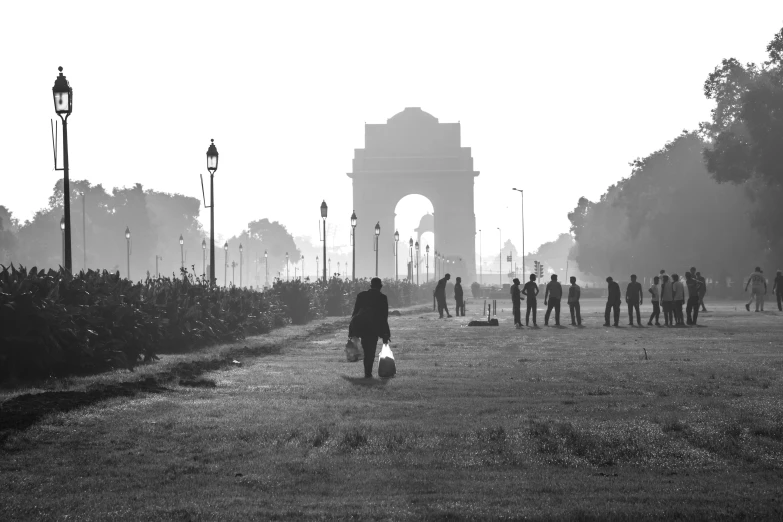 people are walking through the park in the fog