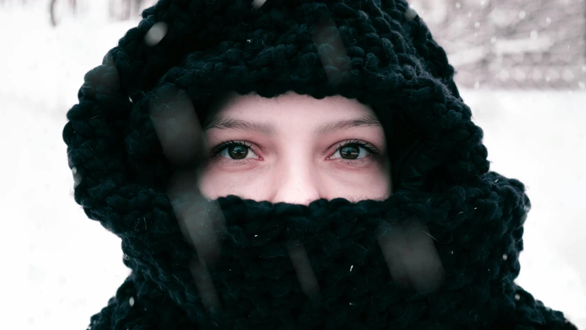 the woman wearing the black winter hat stares into the camera