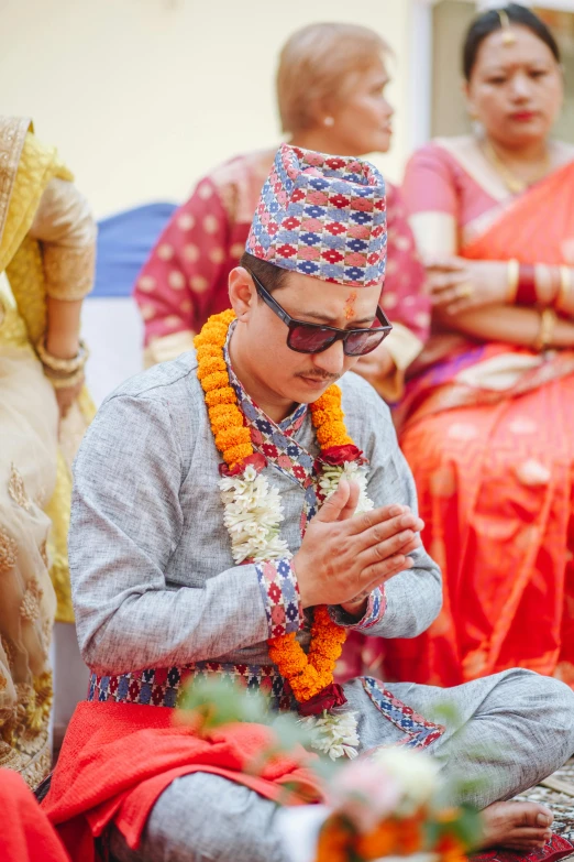 a man sitting down with some flowers in his hands