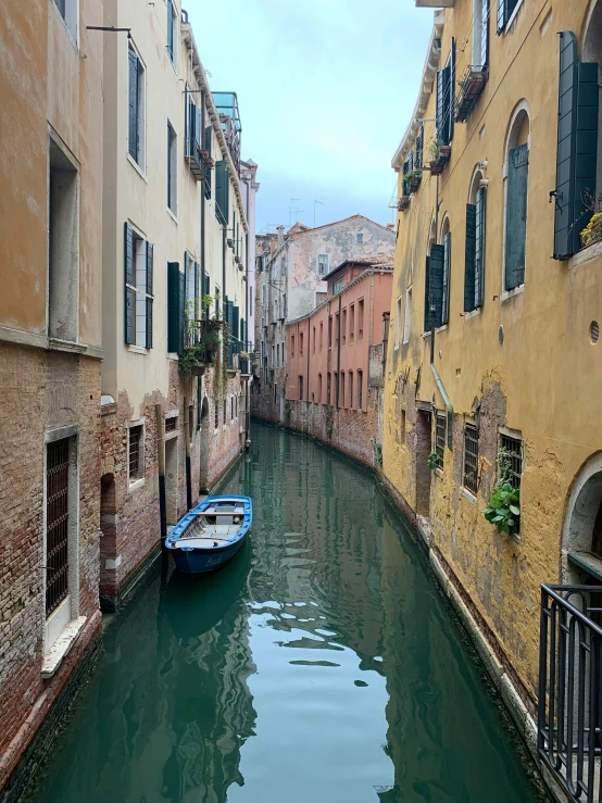 a boat floating in a channel next to some buildings