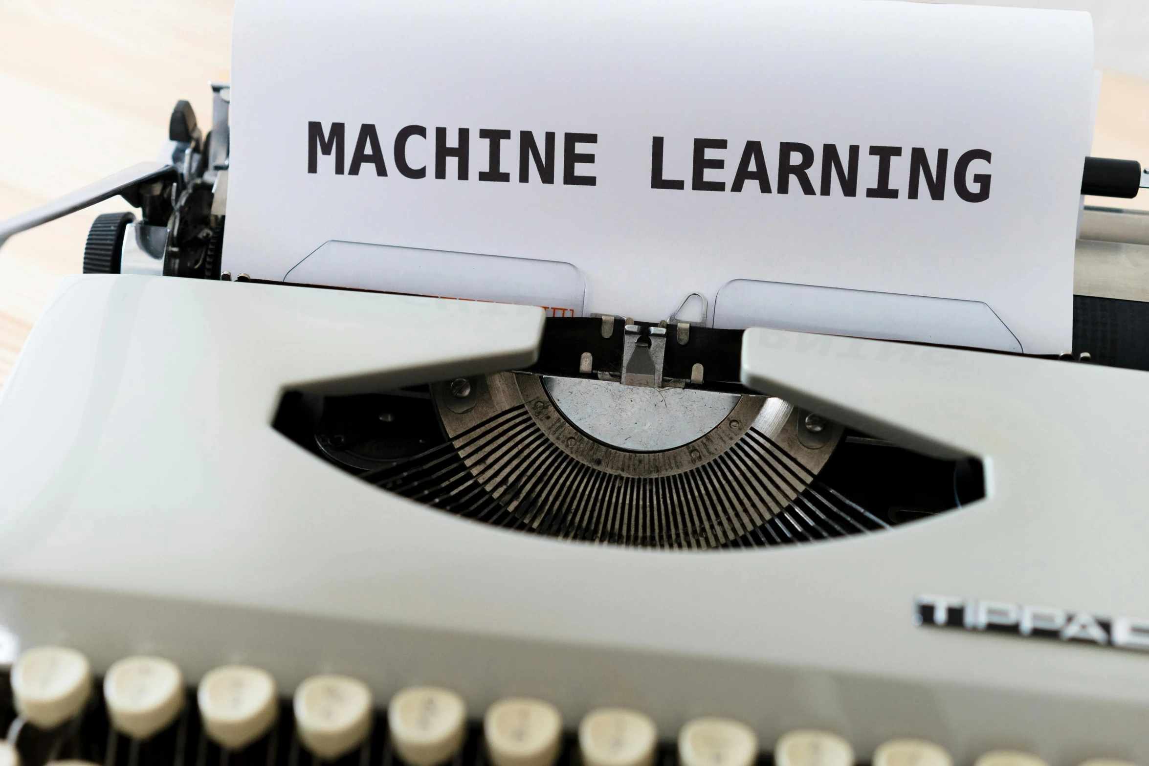 a sheet that says machine learning sitting on an old typewriter