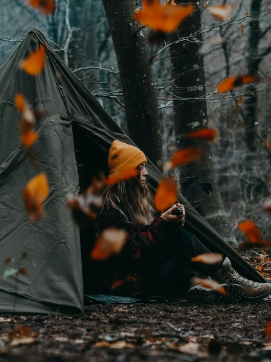 an older person is sitting in a tent and camping