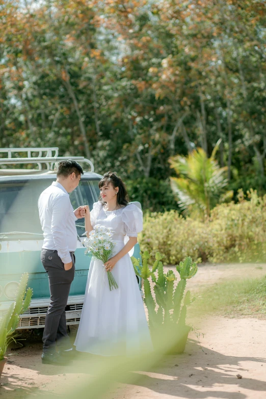 the couple is standing in front of the wedding car