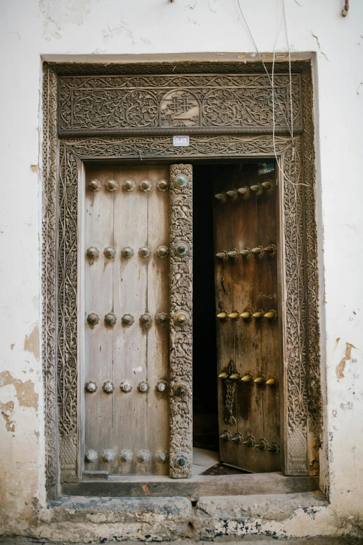 two very old doors are open on an old building