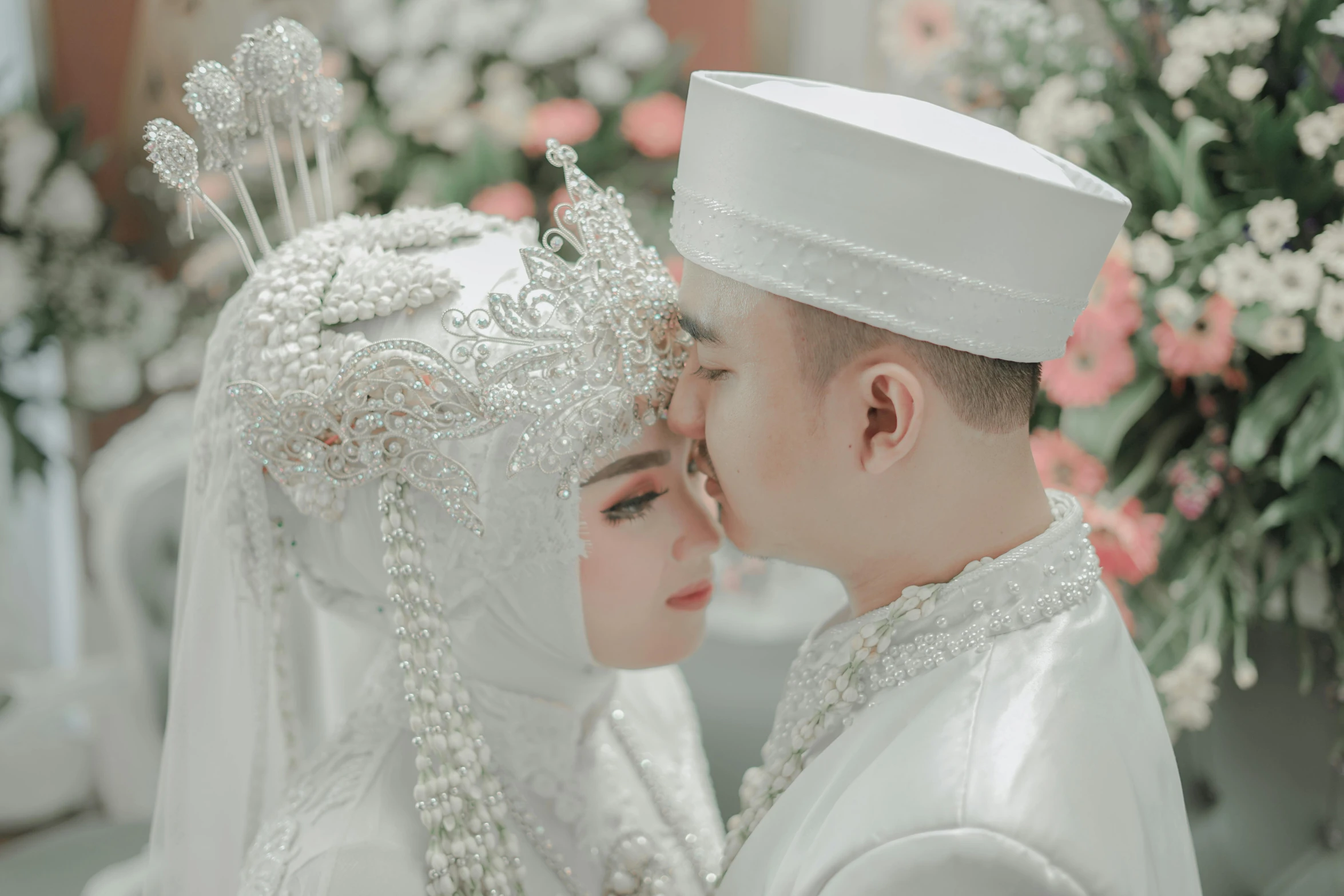 a married couple dressed in white emce each other