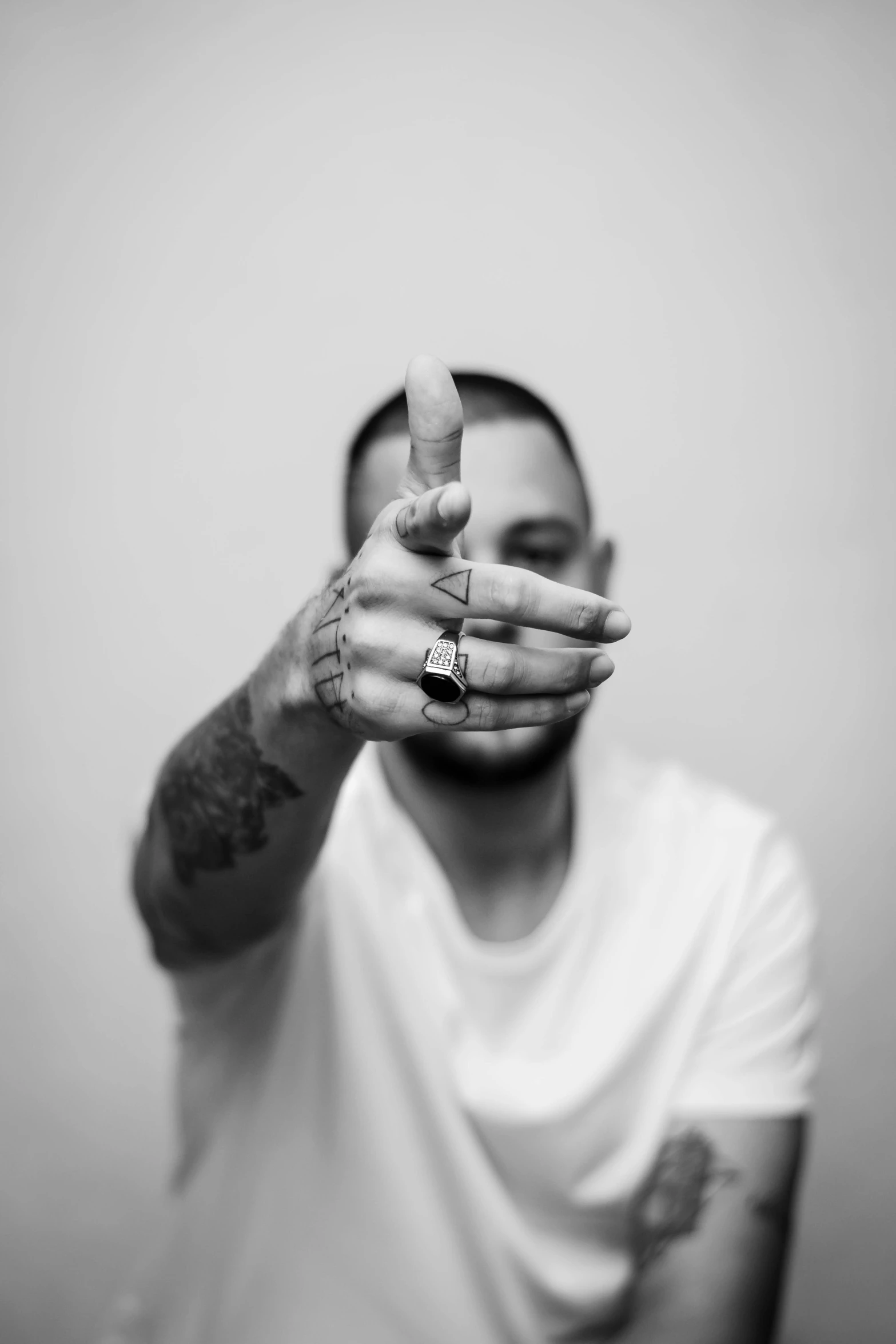 black and white pograph of a young man making a hand sign