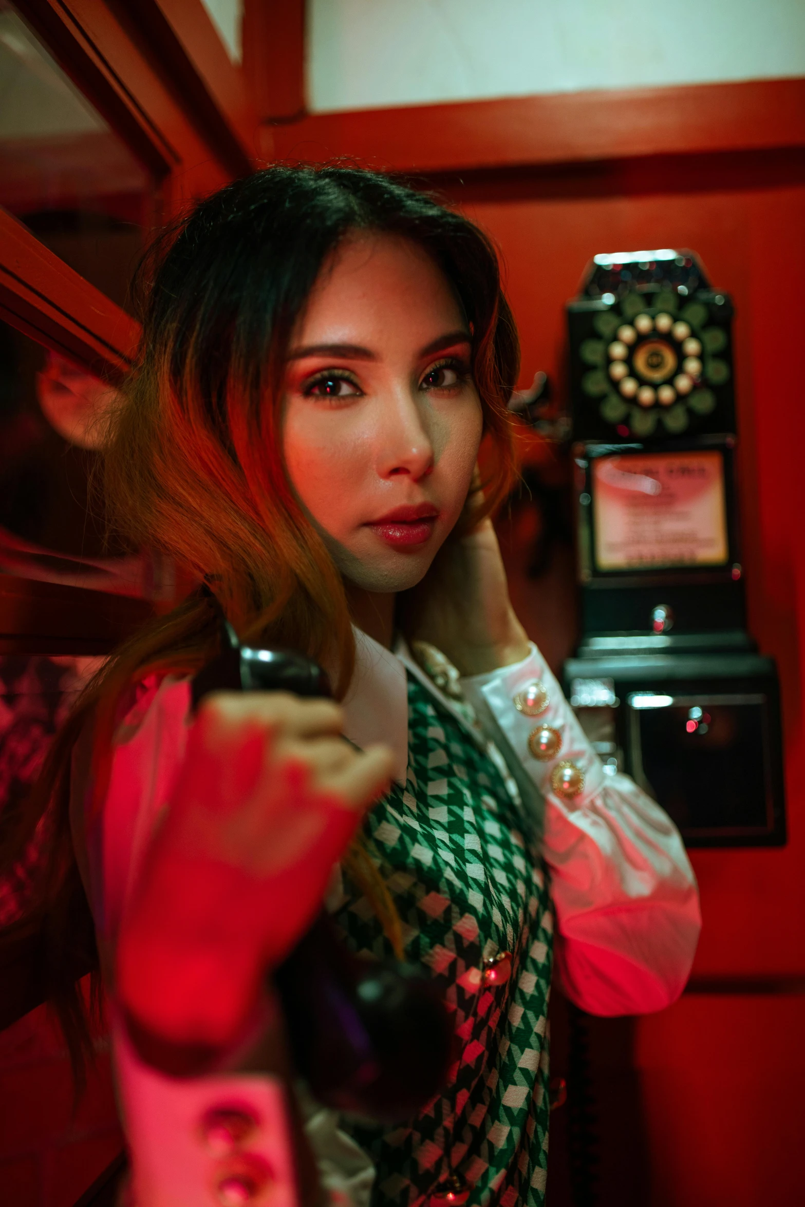 a young woman holding a phone next to a mirror