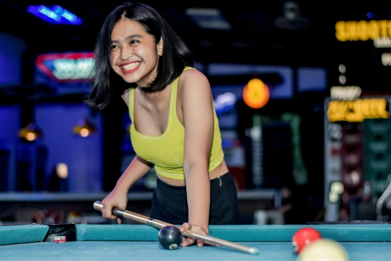 a girl standing in front of a pool table