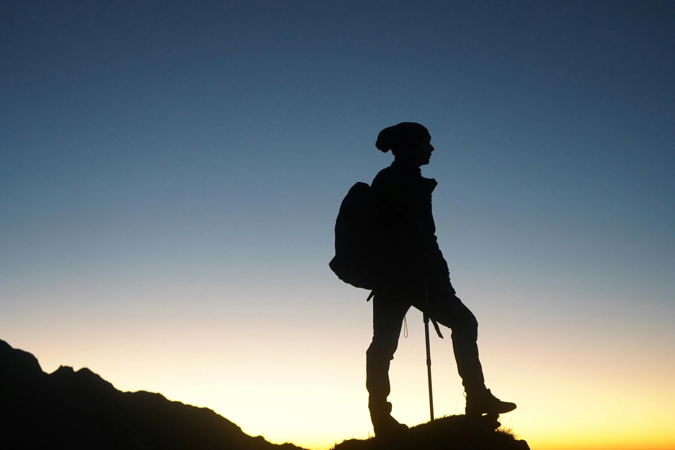 a silhouette of a hiker on top of a mountain