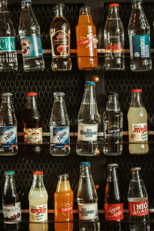 various bottled beverages are lined up against the wall