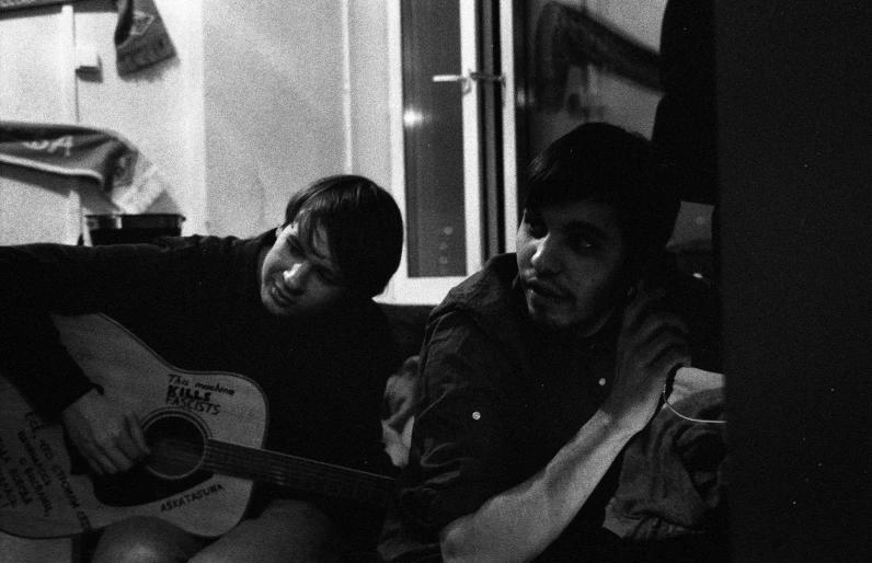 two people sitting next to each other in front of a piano