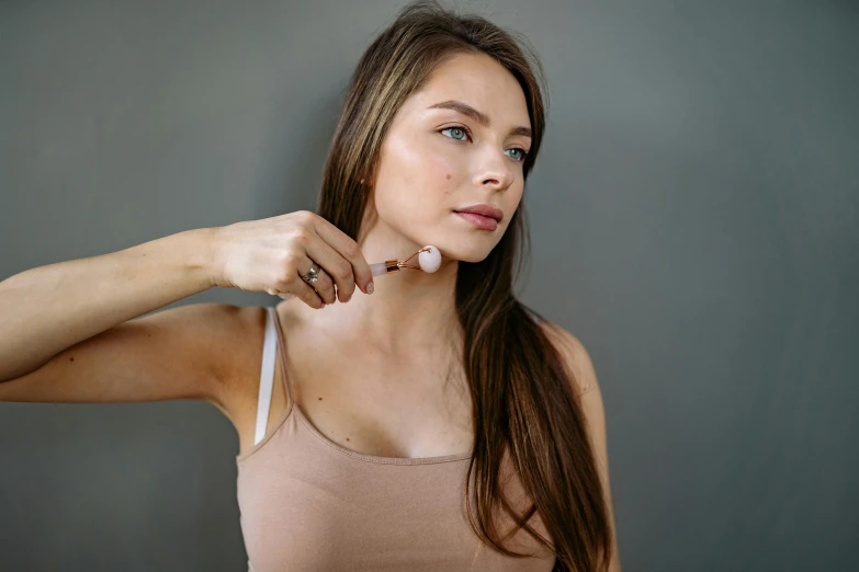 a woman brushing her teeth while holding onto the strap on her strapless top