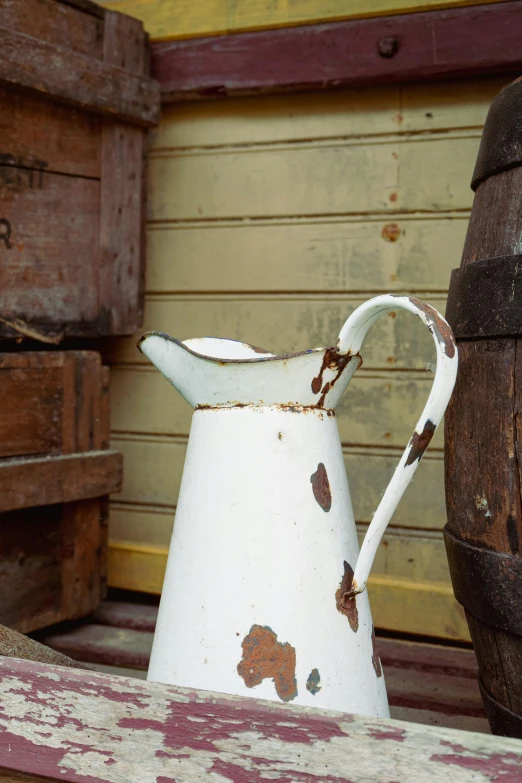 an antique jug is sitting on a bench