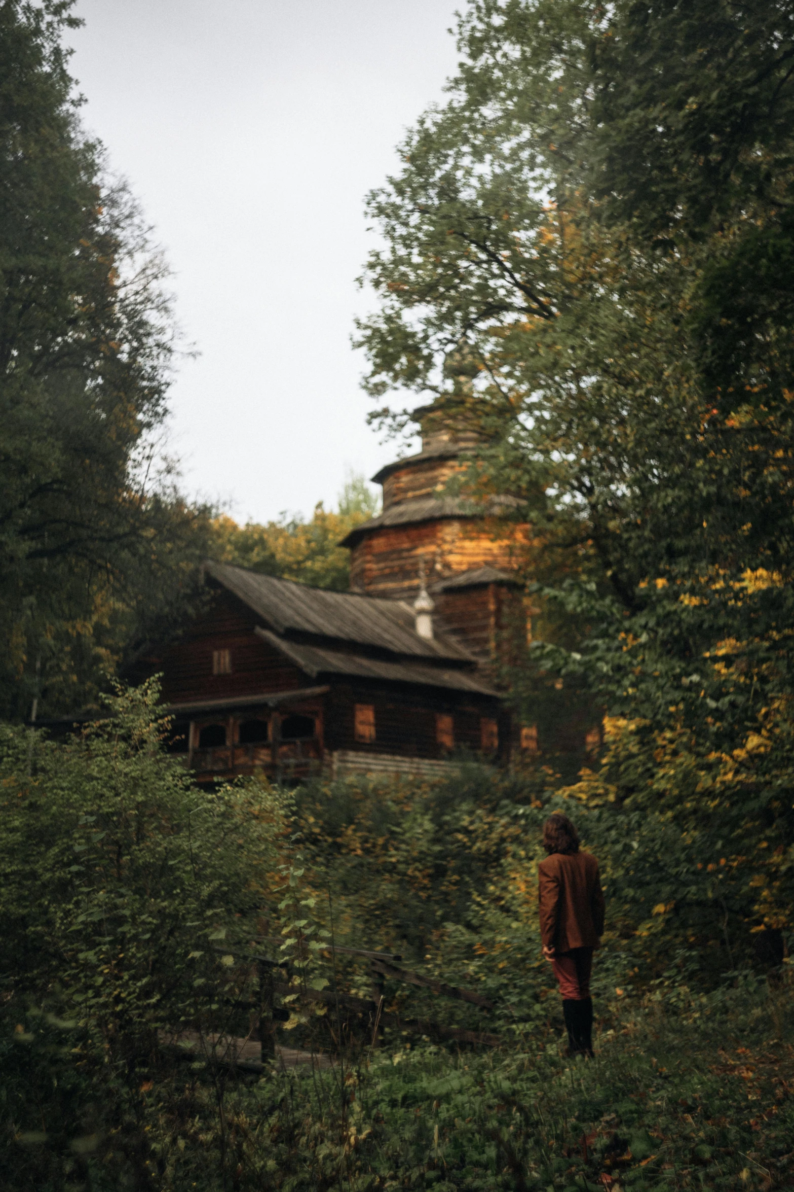 a person is standing in front of an old cabin